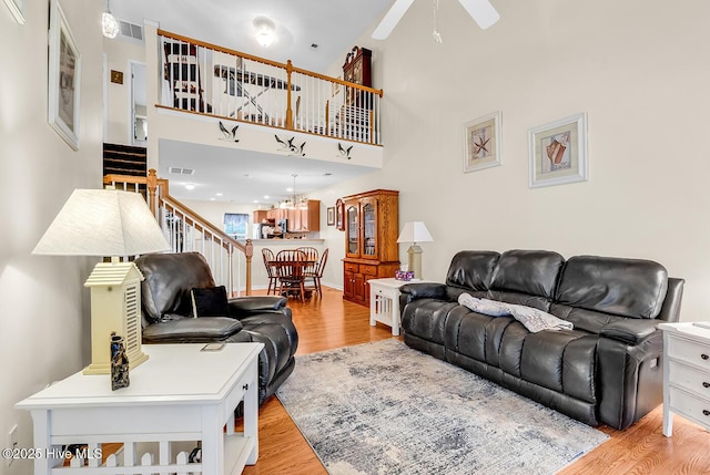 2129 Cass Lake Dr, Calabash, NC 28467 - living area featuring a ceiling fan, light wood-type flooring, stairs, and a chandelier