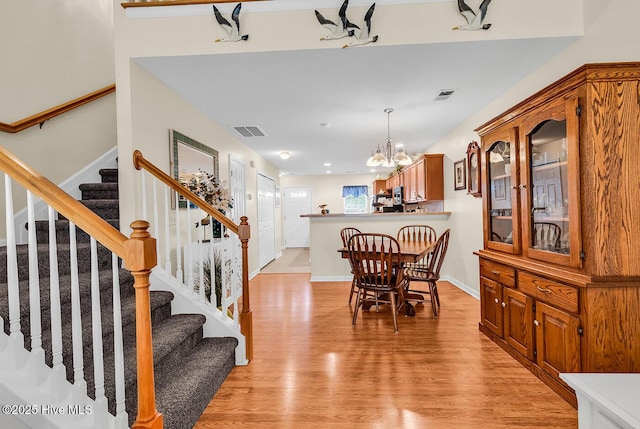 2129 Cass Lake Dr, Calabash, NC 28467 - dining room featuring a chandelier, light wood finished floors, and stairs