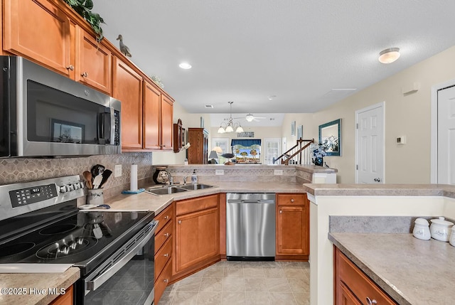 2129 Cass Lake Dr, Calabash, NC 28467 - kitchen featuring appliances with stainless steel finishes, brown cabinetry, a peninsula, light countertops, and recessed lighting