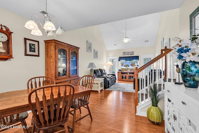 2129 Cass Lake Dr, Calabash, NC 28467 - dining room with light wood-style floors, ceiling fan, stairway, a chandelier, and high vaulted ceiling