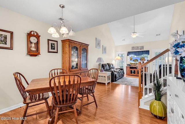 2129 Cass Lake Dr, Calabash, NC 28467 - dining space with a chandelier, light wood-type flooring, stairs, a ceiling fan, and high vaulted ceiling