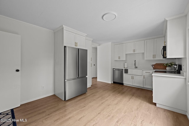 2402 S Lakeview Dr, Newport, NC 28570 - kitchen featuring appliances with stainless steel finishes, light wood finished floors, white cabinets, light countertops, and crown molding