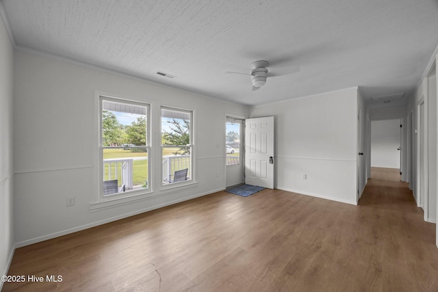 2402 S Lakeview Dr, Newport, NC 28570 - unfurnished bedroom with wood finished floors, multiple windows, crown molding, and ceiling fan