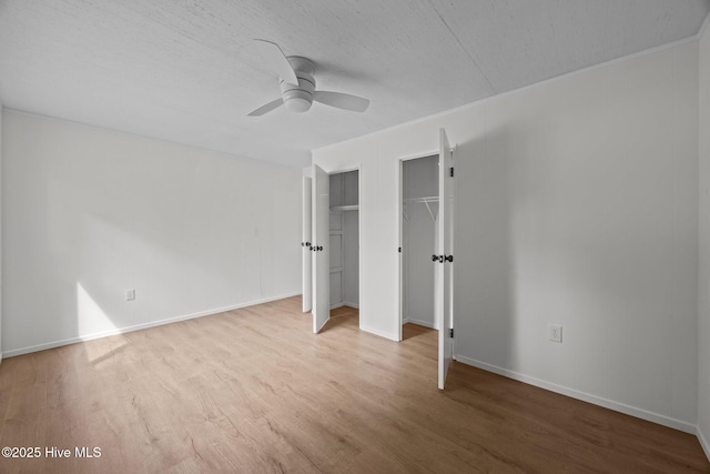 2402 S Lakeview Dr, Newport, NC 28570 - unfurnished bedroom featuring multiple closets, wood finished floors, a ceiling fan, and a textured ceiling