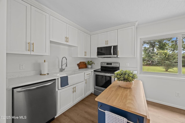 2402 S Lakeview Dr, Newport, NC 28570 - kitchen featuring stainless steel appliances, white cabinetry, wood finished floors, and ornamental molding