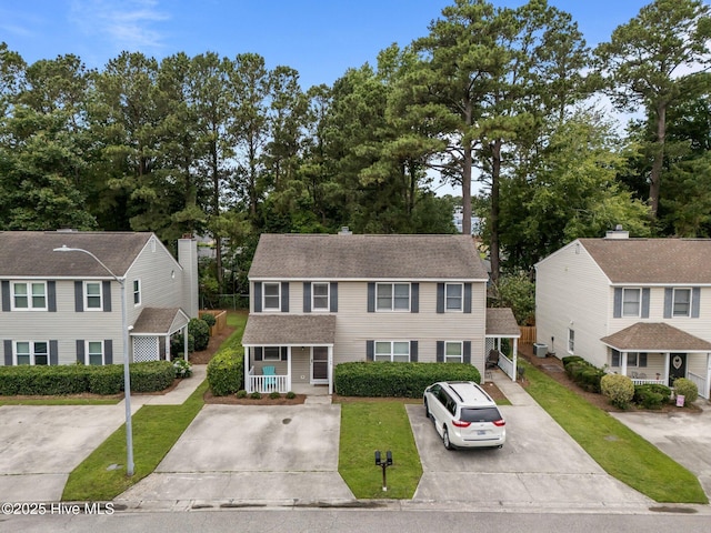 136 Lullwater Dr Unit B, Wilmington, NC 28403 - view of front of property with a porch, a front yard, a shingled roof, and driveway