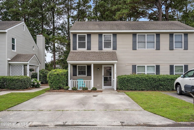 136 Lullwater Dr Unit B, Wilmington, NC 28403 - view of front of property with covered porch, a front yard, and a shingled roof