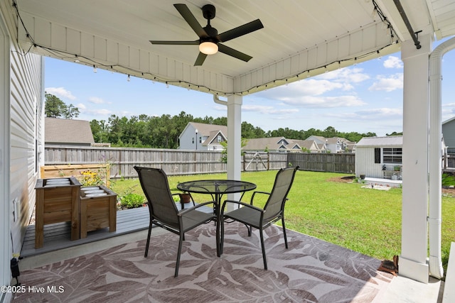 634 Aurora Pl, Hampstead, NC 28443 - fenced backyard featuring a ceiling fan, outdoor dining area, a patio, an outdoor structure, and a residential view