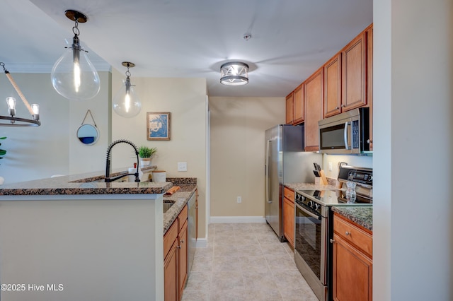 203 Sky Sail Blvd, New Bern, NC 28560 - kitchen with appliances with stainless steel finishes, brown cabinetry, dark stone countertops, and pendant lighting