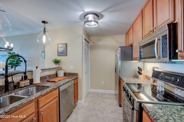 203 Sky Sail Blvd, New Bern, NC 28560 - kitchen with stainless steel appliances, brown cabinets, dark stone countertops, pendant lighting, and light tile patterned flooring
