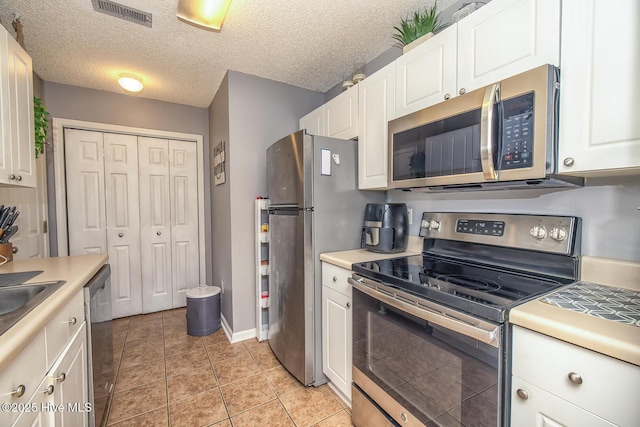 2505 Legend Dr, Wilmington, NC 28405 - kitchen featuring stainless steel appliances, white cabinetry, light countertops, and light tile patterned flooring