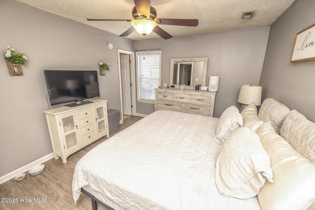 2505 Legend Dr, Wilmington, NC 28405 - bedroom featuring light wood-type flooring, a textured ceiling, and a ceiling fan