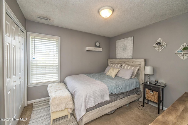 2505 Legend Dr, Wilmington, NC 28405 - carpeted bedroom featuring a closet, multiple windows, and a textured ceiling