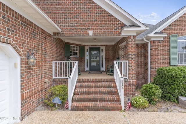 512 Shell Dr, Kure Beach, NC 28449 - view of exterior entry with brick siding and a porch
