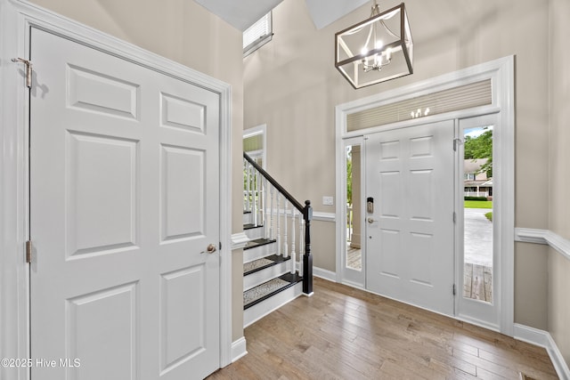 376 Red Fox Run Dr, Wallace, NC 28466 - foyer entrance with a chandelier, stairs, light wood-style floors, and a towering ceiling