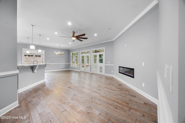 376 Red Fox Run Dr, Wallace, NC 28466 - unfurnished living room featuring ceiling fan, a glass covered fireplace, crown molding, light wood finished floors, and recessed lighting