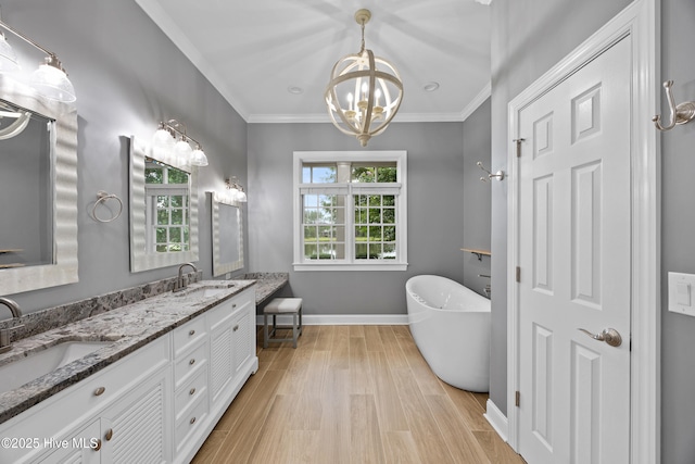 376 Red Fox Run Dr, Wallace, NC 28466 - bathroom featuring double vanity, a freestanding tub, wood finished floors, a chandelier, and ornamental molding