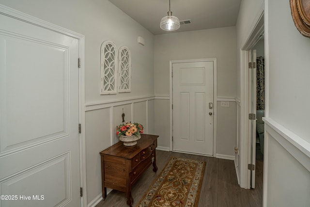 9363 Eagle Ridge Dr, Calabash, NC 28467 - entryway featuring dark wood-style floors and a wainscoted wall