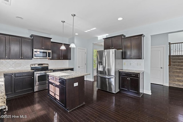 109 Creek End Ct, Swansboro, NC 28584 - kitchen featuring appliances with stainless steel finishes, dark brown cabinets, backsplash, light stone countertops, and recessed lighting