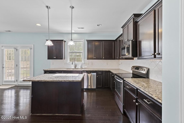 109 Creek End Ct, Swansboro, NC 28584 - kitchen with stainless steel appliances, dark brown cabinetry, tasteful backsplash, a kitchen island, and recessed lighting