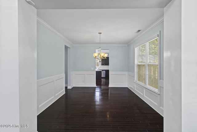 109 Creek End Ct, Swansboro, NC 28584 - unfurnished dining area with a chandelier, dark wood-style flooring, ornamental molding, a wainscoted wall, and a decorative wall