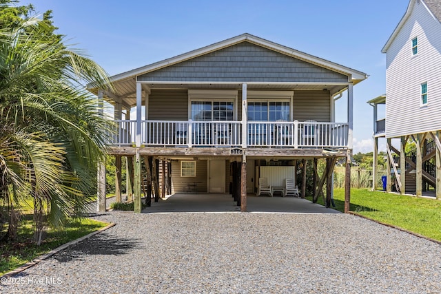 316 E Dolphin Dr, Oak Island, NC 28465 - beach home with a carport, gravel driveway, stairs, and a porch