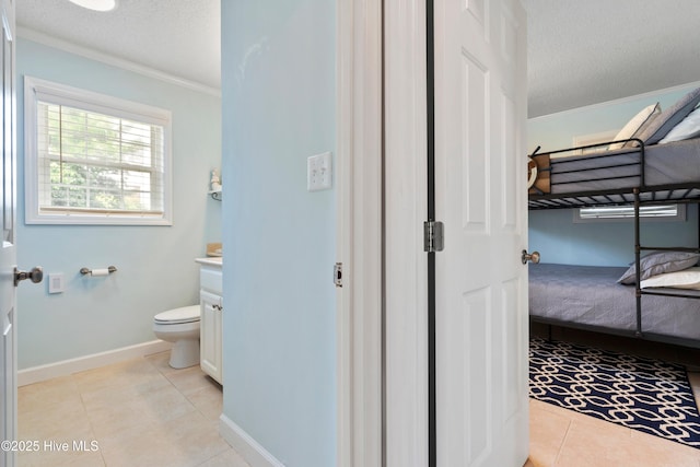 316 E Dolphin Dr, Oak Island, NC 28465 - bathroom with vanity, crown molding, tile patterned flooring, a textured ceiling, and ensuite bath