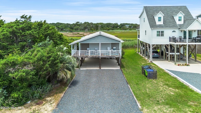 316 E Dolphin Dr, Oak Island, NC 28465 - beach home with a carport, driveway, a front yard, and stairs