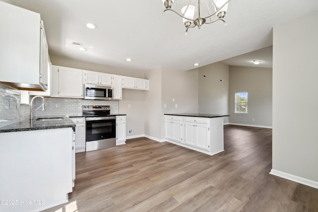 802 Mayfield Ct, Wilmington, NC 28411 - kitchen with appliances with stainless steel finishes, white cabinetry, light wood-type flooring, tasteful backsplash, and a chandelier