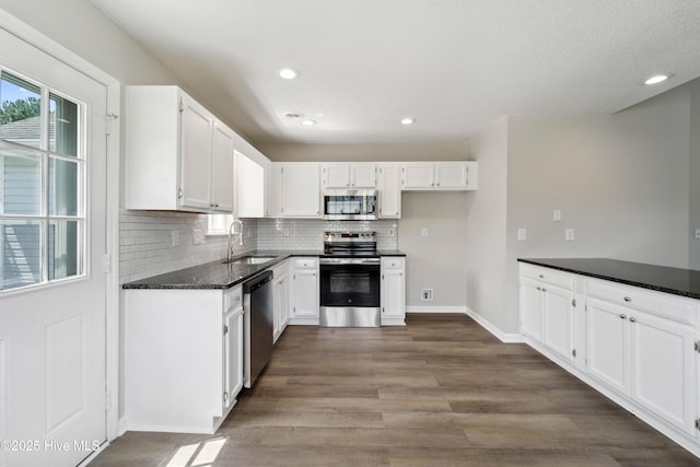 802 Mayfield Ct, Wilmington, NC 28411 - kitchen featuring appliances with stainless steel finishes, white cabinetry, tasteful backsplash, dark wood-type flooring, and recessed lighting