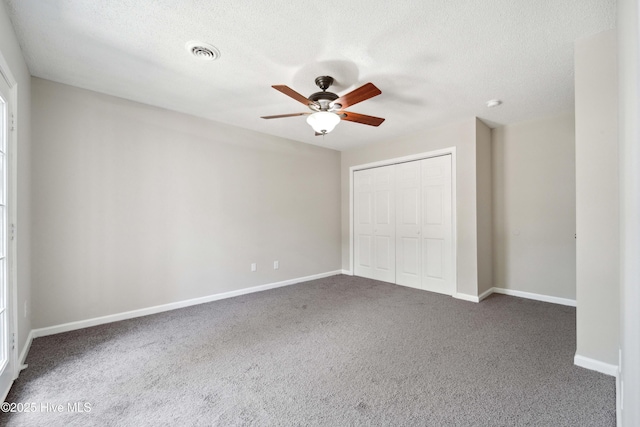802 Mayfield Ct, Wilmington, NC 28411 - unfurnished bedroom with dark carpet, a closet, a textured ceiling, and ceiling fan