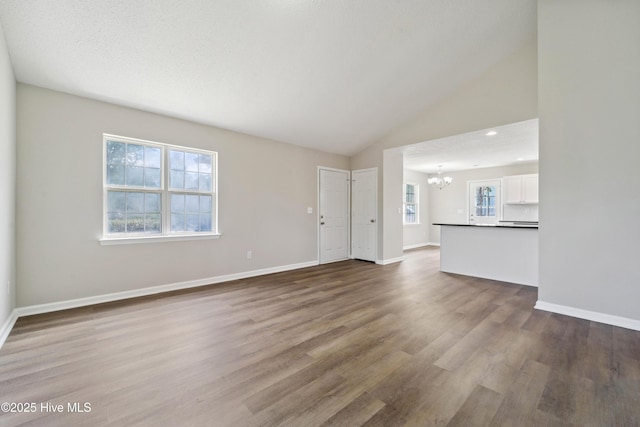 802 Mayfield Ct, Wilmington, NC 28411 - unfurnished living room featuring a chandelier, wood finished floors, and vaulted ceiling