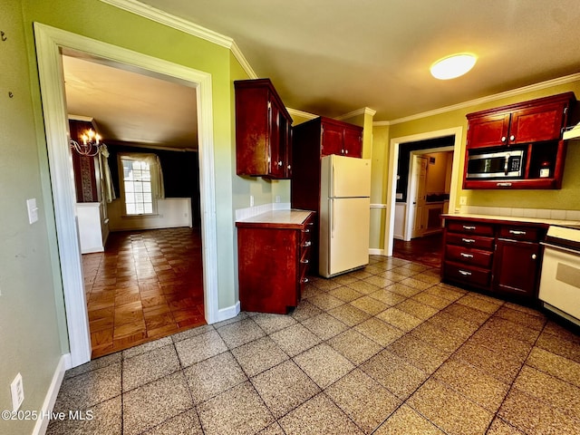 9550 NC-171, Williamston, NC 27892 - kitchen with freestanding refrigerator, reddish brown cabinets, stainless steel microwave, crown molding, and light countertops