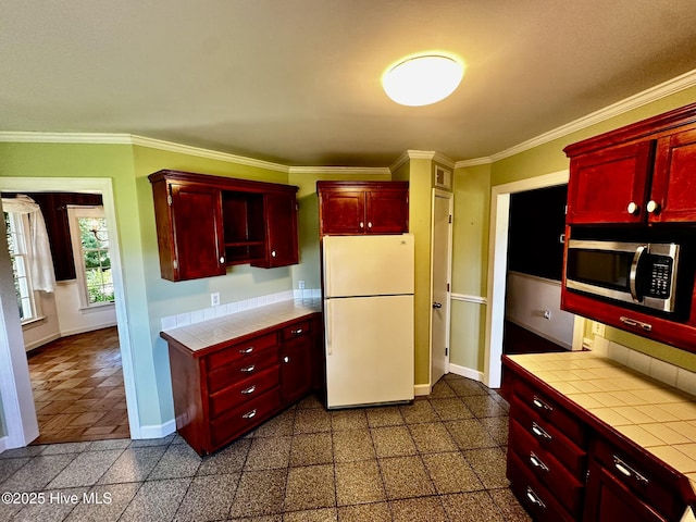 9550 NC-171, Williamston, NC 27892 - kitchen with freestanding refrigerator, tile counters, dark brown cabinets, stainless steel microwave, and crown molding