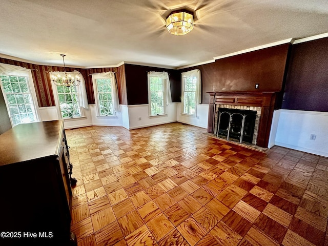 9550 NC-171, Williamston, NC 27892 - unfurnished living room featuring a chandelier, a tiled fireplace, healthy amount of natural light, ornamental molding, and wainscoting