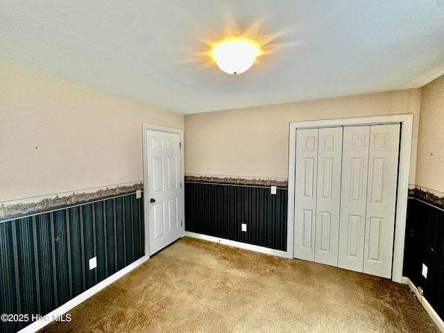 9550 NC-171, Williamston, NC 27892 - unfurnished bedroom featuring a wainscoted wall, carpet flooring, and a closet