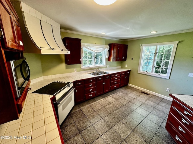 9550 NC-171, Williamston, NC 27892 - kitchen featuring white range with electric stovetop, ornamental molding, dark brown cabinets, tile countertops, and recessed lighting