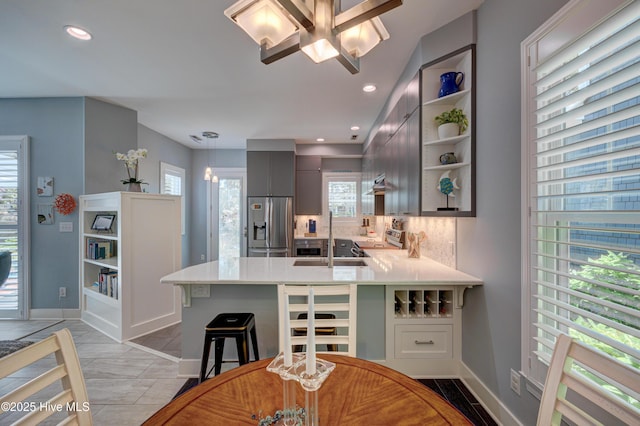 8508 Hammock Dunes Dr, Wilmington, NC 28411 - kitchen featuring appliances with stainless steel finishes, a peninsula, light countertops, open shelves, and a ceiling fan