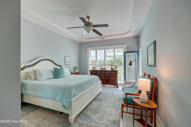 8508 Hammock Dunes Dr, Wilmington, NC 28411 - bedroom with a tray ceiling and a ceiling fan