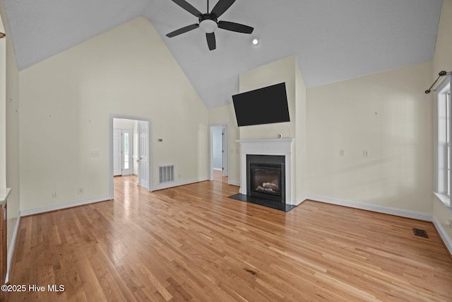 2639 Plumosa Dr, Grimesland, NC 27837 - unfurnished living room with high vaulted ceiling, ceiling fan, a fireplace with flush hearth, and light wood-style floors