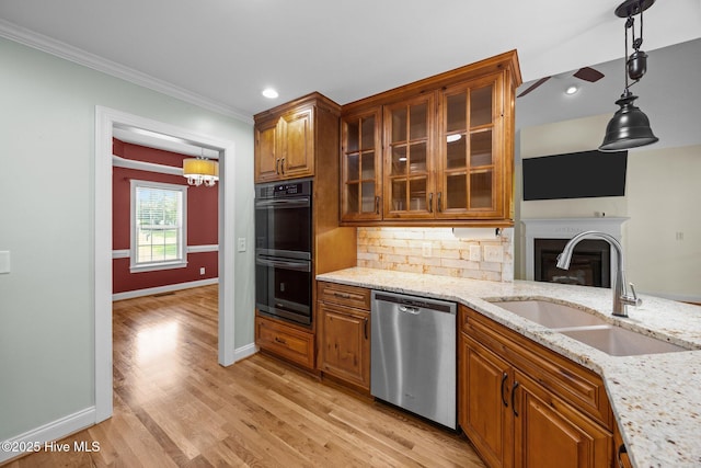 2639 Plumosa Dr, Grimesland, NC 27837 - kitchen with stainless steel dishwasher, brown cabinetry, crown molding, light stone counters, and tasteful backsplash