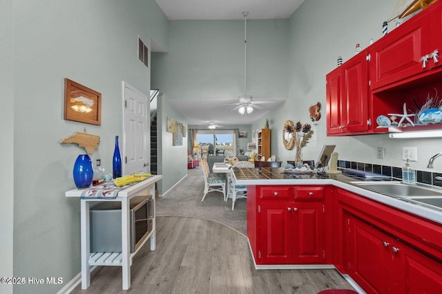 1785 New River Inlet Rd Unit 2, North Topsail Beach, NC 28460 - kitchen featuring a peninsula, light wood-style floors, a high ceiling, and a ceiling fan