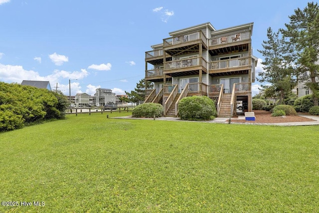 1785 New River Inlet Rd Unit 2, North Topsail Beach, NC 28460 - rear view of house with stairs, a lawn, and a wooden deck
