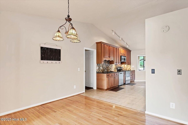 120 Shagbark Ct, Seven Lakes, NC 27376 - kitchen with appliances with stainless steel finishes, vaulted ceiling, a chandelier, tasteful backsplash, and dark countertops