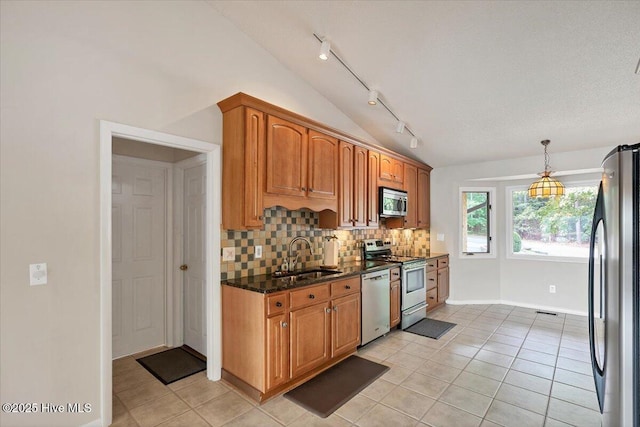 120 Shagbark Ct, Seven Lakes, NC 27376 - kitchen with stainless steel appliances, track lighting, vaulted ceiling, light tile patterned flooring, and decorative backsplash