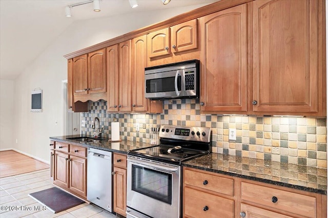 120 Shagbark Ct, Seven Lakes, NC 27376 - kitchen with appliances with stainless steel finishes, lofted ceiling, dark stone counters, backsplash, and light tile patterned floors