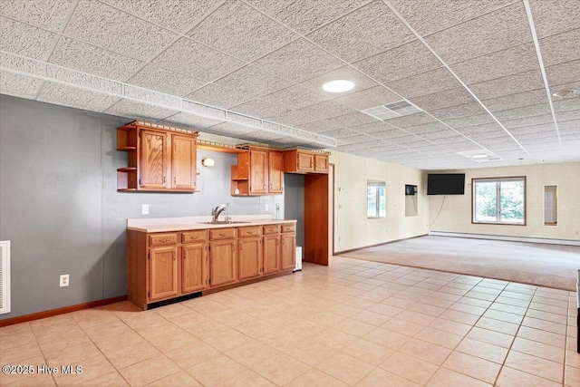 120 Shagbark Ct, Seven Lakes, NC 27376 - kitchen featuring open shelves, baseboard heating, light countertops, brown cabinets, and open floor plan