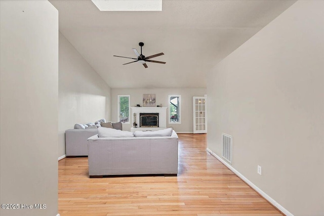 120 Shagbark Ct, Seven Lakes, NC 27376 - living area with ceiling fan, lofted ceiling, wood finished floors, a glass covered fireplace, and a skylight