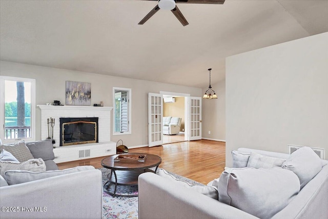 120 Shagbark Ct, Seven Lakes, NC 27376 - living area featuring wood finished floors, a chandelier, ceiling fan, a fireplace, and a wall mounted AC