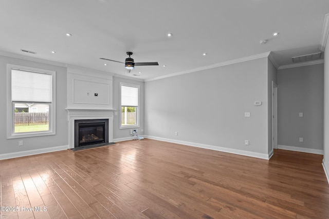 1035 Bent Blade Ln, Wilmington, NC 28411 - unfurnished living room with ornamental molding, a ceiling fan, hardwood / wood-style flooring, a glass covered fireplace, and recessed lighting
